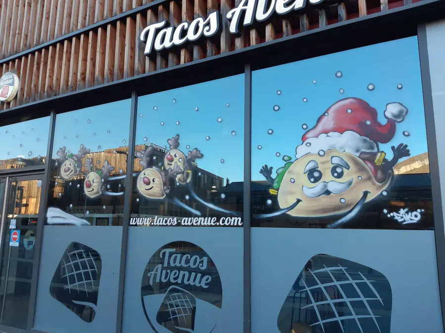 Vitrine de Noël du restaurant Tacos Avenue décorée de personnages rigolos à bonnet de Père Noël